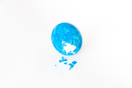 Eggs peck with blue Easter egg and white backgroundの写真素材