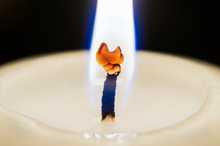 Closeup of a white burning candleの写真素材