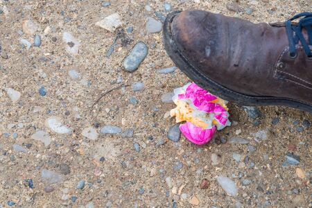 Violet easter egg is getting scrunched by a shoeの写真素材