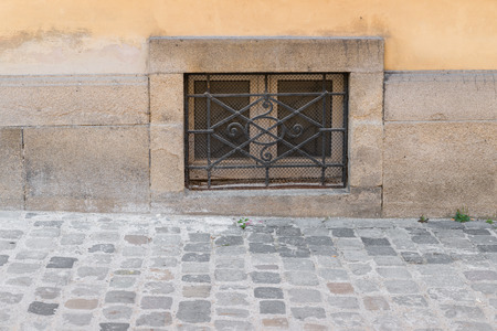 Old rusty cellar window with iron grating