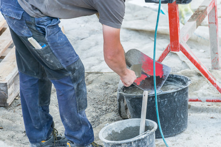 Construction worker is cleaning a shovelの写真素材