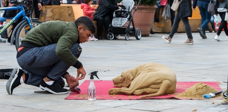 Regensburg, Bavaria, Germany, October 24, 2017: Street artist is modeling a dog with sand in the pedestrian zone in Regensburg, Germanyのeditorial素材