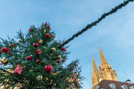 Christmas tree on a Christmas market in Regensburg with view to the cathedral, Germanyの写真素材