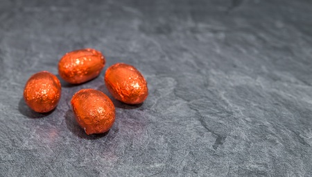 Red chocolate easter eggs in front of gray backgroundの写真素材