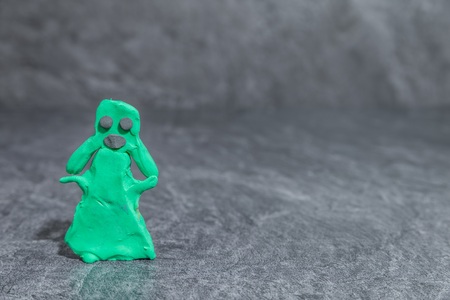 Woman made dough green play in front of gray backgroundの写真素材