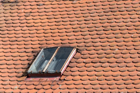 Old roof with shingles and roof windowsの写真素材