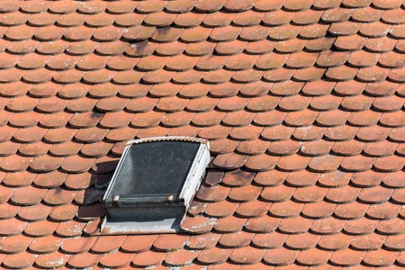 Old roof with shingles and roof windowsの写真素材