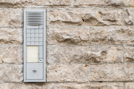 Worn doorbell with intercom on a house wallの写真素材
