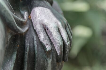 Detail shot of a female hand of a bronze statue of a woman in a park, Germanyの写真素材