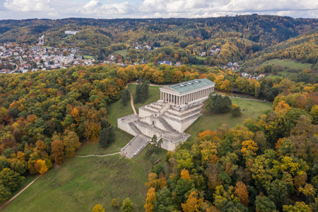 Picture of an aerial view with a drone of the Walhalla building in ancient Greek architecture as a memorial for important persons of German language with sky clouds tree mountain in Regensburg, Germanのeditorial素材