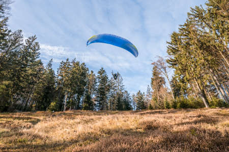 Taking off hobby paraglider pilot on a mountain slope with professional equipment in autumn, Germanyの写真素材