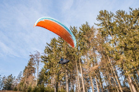 Taking off hobby paraglider pilot on a mountain slope with professional equipment in autumn, Germanyの写真素材