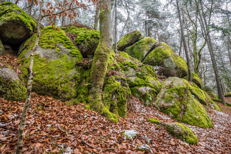 Ancient weathered megalithic granite rock formation with cave and breakthrough in Bavarian forest...