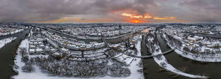 Panorama of Regensburg city in Bavaria with the river Danube the cathedral and the stone bridge in winter with ice and snow at sunset and snowstorm, Germanyのeditorial素材