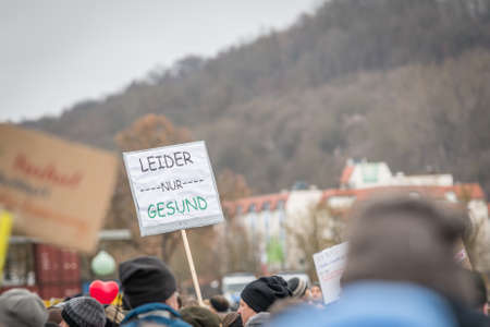 Regensburg, Bavaria, Germany, January 26, 2022: Demonstrator at an anti-corona demonstration in Regensburg with sign and text in German - unfortunately only healthy - , Germanyのeditorial素材