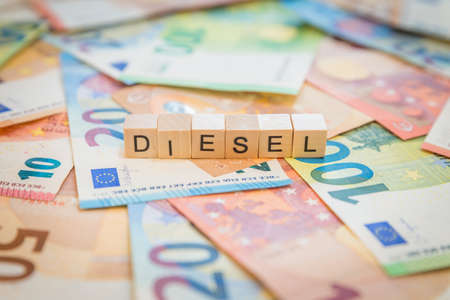 The word Diesel on banknotes Euro notes written with wooden cubesの写真素材