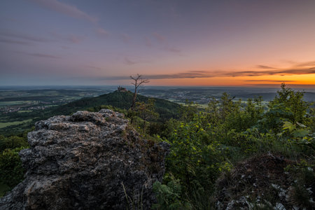 Sunrise at Zeller Horn with view to medieval knight castle Burg Hohenzollern with beautiful colored clouds in the sky in autumn in Bisingen Hechingen, Germanyの写真素材