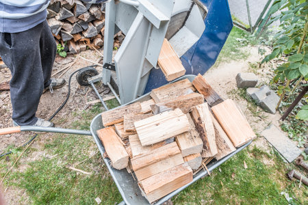 Close up of a wheelbarrow fully loaded with logs working and sawing wood, Germanyの写真素材