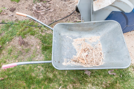 Close up of empty wheelbarrow with wood splinters doing woodworking and sawing wood, Germanyの写真素材