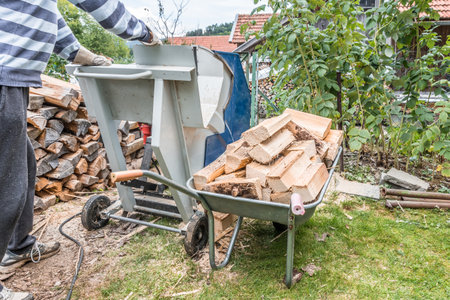 Close up of a wheelbarrow fully loaded with logs working and sawing wood, Germanyの写真素材