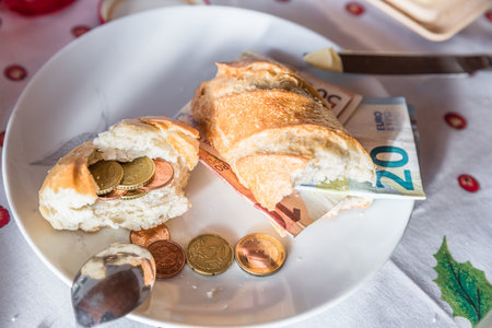 Set breakfast table with breakfast of coffee sugar milk and butter and roll covered with euro coins and banknotes on plate, Germanyの写真素材