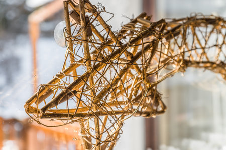 shooting star woven from willow wood illuminated on a window in winter at Christmas time, Germanyの写真素材