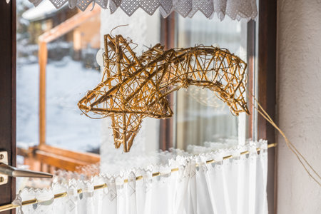 shooting star woven from willow wood illuminated on a window in winter at Christmas time, Germanyの写真素材