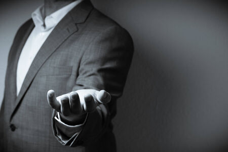 The image displays on individual dressed in a suit holding one hand to the front with a giving gesture. Only the personの写真素材