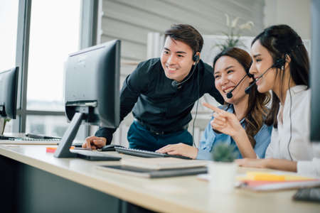 Smiling young officer working and looking camera at office.の写真素材