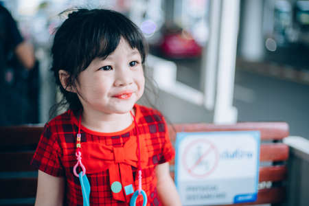 Cute asian girl playing and eating chocolate at the park outdoor.
