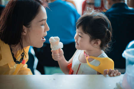 Mother and cute girl playing together at the park outdoorの写真素材