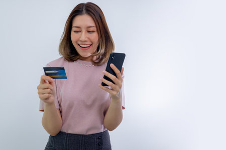 Asian woman holding credit card and looking at smartphone app, buying, order delivery with Online...