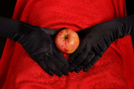 Red apple on abdomen with handの写真素材