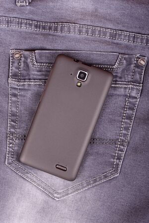 Mobile phone on the jeans background, detailの写真素材
