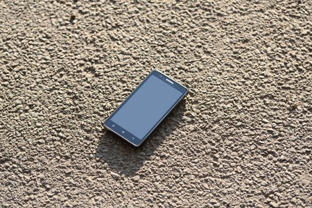Lost cellphone on asphalt a sunny dayの写真素材