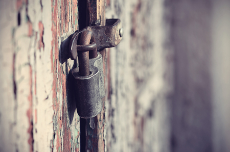 Closeup photo of a padlock on wooden doorの写真素材