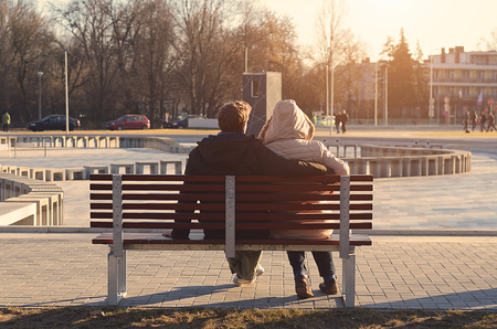 Couple sitting on bench in the park a sunny dayの写真素材