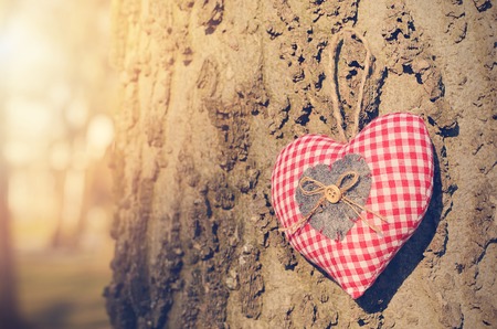 Vintage photo of a heart shape hanging on wooden background