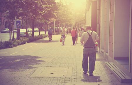 People walking in the street. Vintage toned photoの写真素材