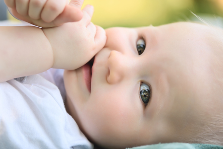 Closeup photo of adorable baby in park, detailの写真素材