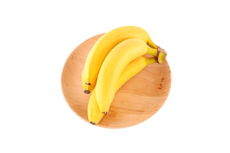 Ripe banana on wooden plate isolated on a white backgroundの写真素材