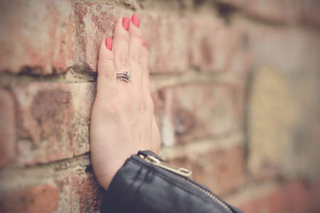 Soft photo of woman hand on brick wallの写真素材