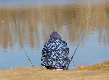 Fisherman sit on the river bank and waitの写真素材