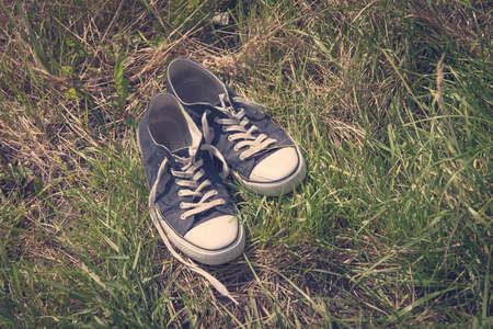 Vintage photo of sneakers in the grassの写真素材