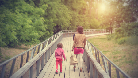Beauty woman and her children walking on bridge a sunny dayの写真素材