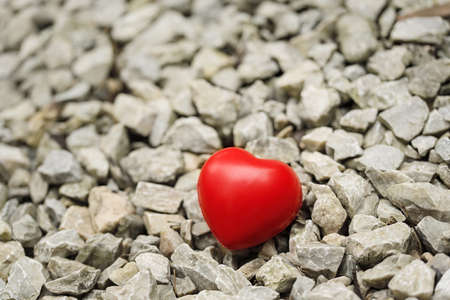 Red heart shape on gravel background. Love symbolの写真素材