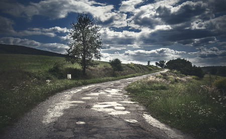 Dramatic photo of the country road a cloudy dayの写真素材