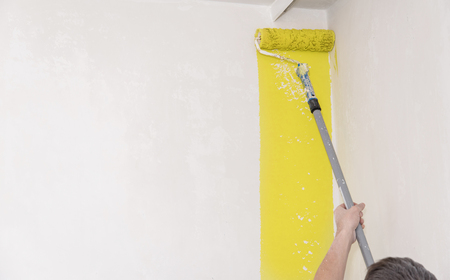 Painter use paint roller on white wallの写真素材