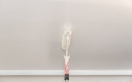 Painter use paint roller on white wallの写真素材
