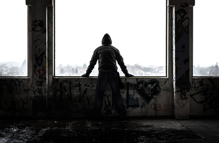 Man standing in old abandoned ruin. Damaged building